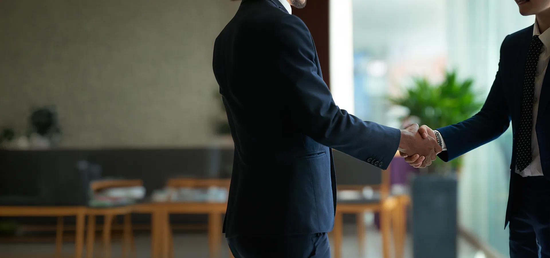 Two consultants shaking hands in a meeting room after agreeing a slip testing engagement
